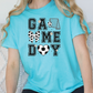 a woman sitting on a couch wearing a game day shirt