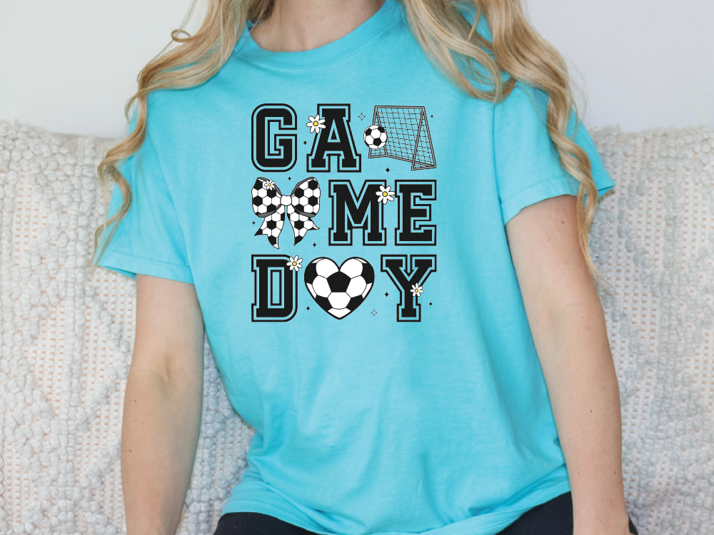 a woman sitting on a couch wearing a game day shirt