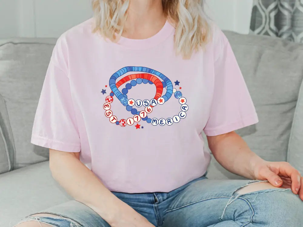 a woman sitting on a couch wearing a pink shirt