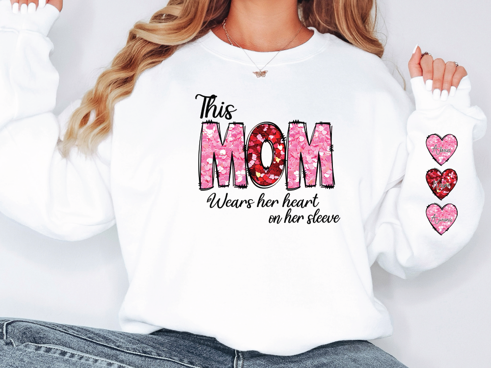 a woman wearing a white shirt that says, this mom wears her heart on her