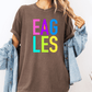 A person wearing a brown t-shirt with the word "EAGLES" printed in colorful letters.