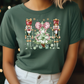 a woman wearing a green t - shirt with a christmas scene on it