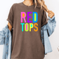 A person wearing a brown t-shirt with the text "RED TOPS" in colorful letters, along with a denim jacket, stands against a white background.