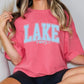 a woman sitting on a chair wearing a pink lake days shirt