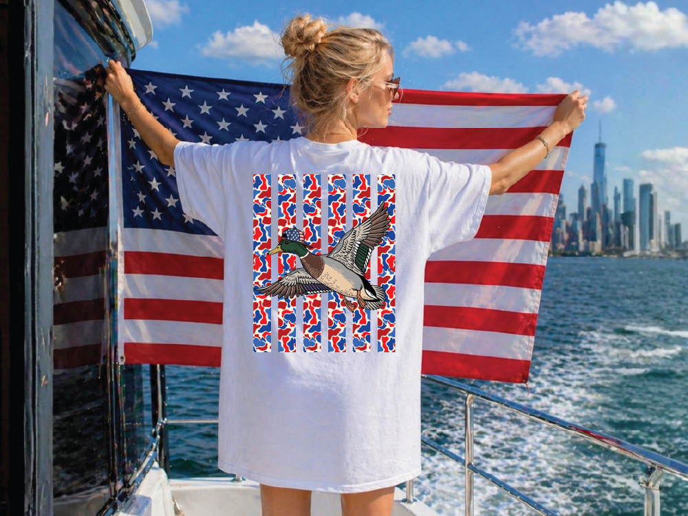 A woman stands on a boat holding an American flag, with a city skyline visible in the background.