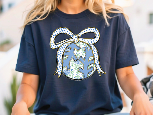 A woman wearing a blue t-shirt with a graphic design of a bow and snowflakes on it.