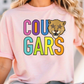 A woman wearing a pink t-shirt with the text "COU GARS" printed on it.