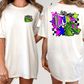 A white t-shirt with a colorful graphic design on the back, featuring a green dinosaur and various geometric shapes and patterns.