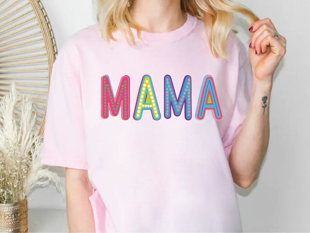 a woman wearing a pink shirt with the word mama printed on it