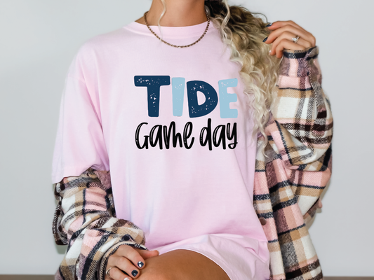 a woman wearing a pink shirt that says tide game day