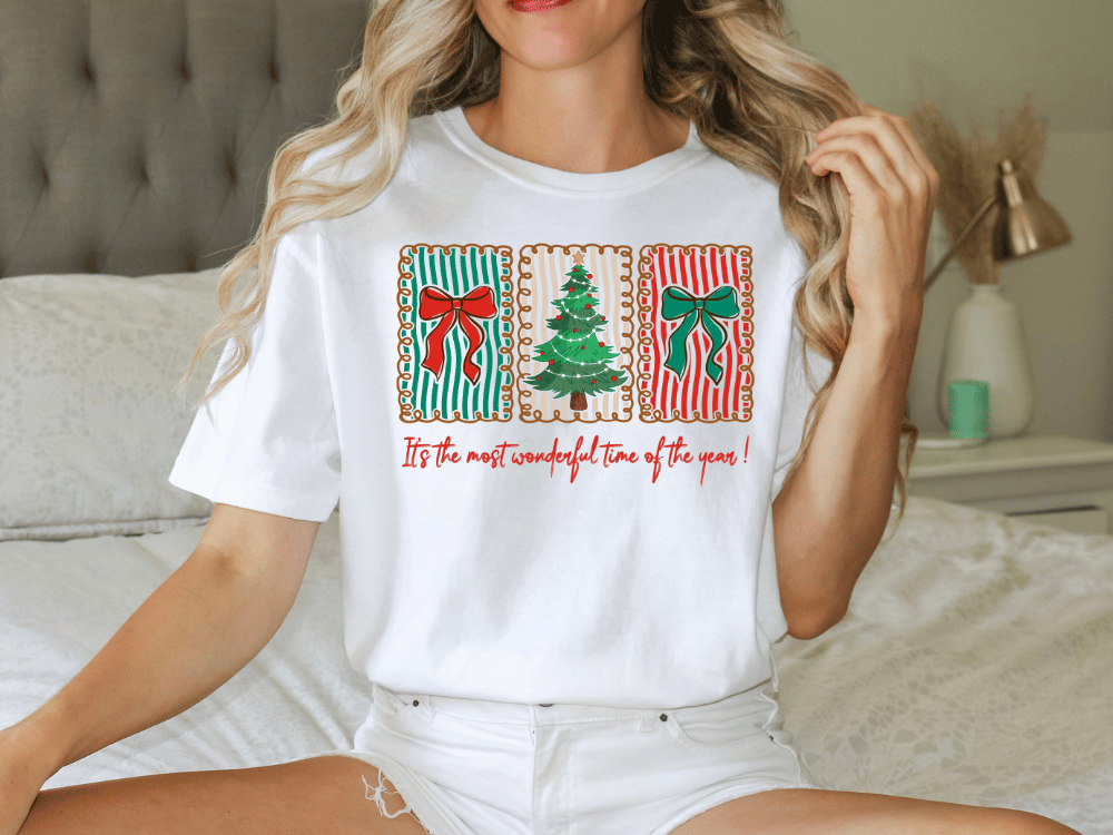 A woman wearing a white t-shirt with a graphic design of Christmas-themed elements, including a Christmas tree, bows, and ribbons.