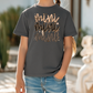 a little girl wearing a t - shirt with a name on it