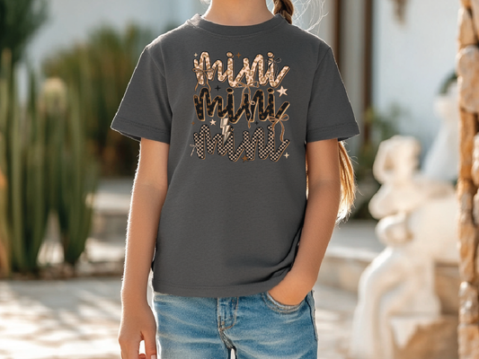 a little girl wearing a t - shirt with a name on it