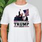 a man wearing a trump t - shirt in front of a plant