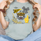 A woman wearing a grey t-shirt with a graphic design featuring a tiger and various text elements.
