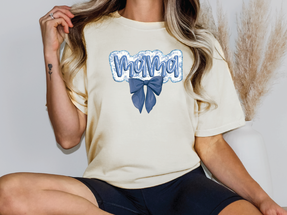 a woman sitting on a chair wearing a t - shirt with a bow on it