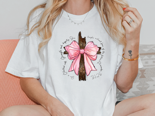 a woman wearing a white shirt with a pink bow on it