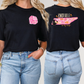 two women wearing black t - shirts with pink designs on them