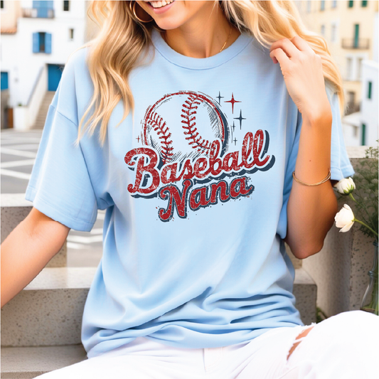 A woman wearing a light blue t-shirt with a baseball graphic and the text "Baseball Nana" printed on it.