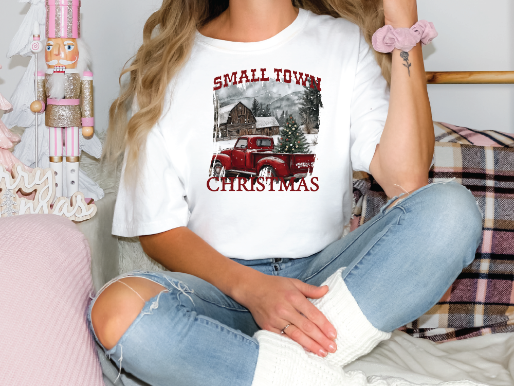 a woman sitting on a couch wearing a t - shirt with a red truck on