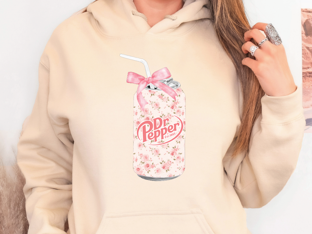 a woman in a pink hoodie holding a drink