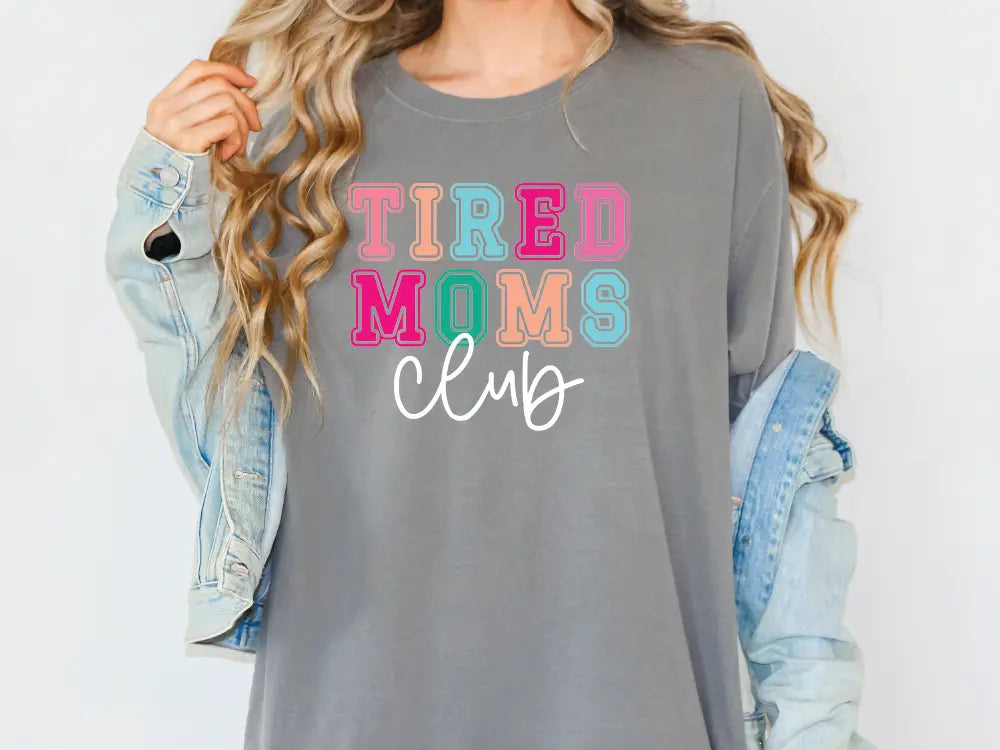 a woman wearing a shirt that says tired moms club