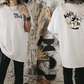 a woman standing in front of a mirror wearing a mickey mouse t - shirt