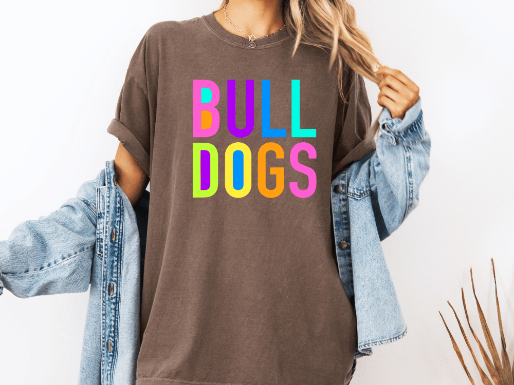 A person wearing a brown t-shirt with the text "Bull Dogs" in colorful letters.