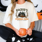 a woman sitting on a bed holding a pumpkin mug