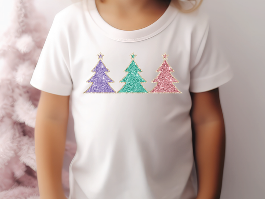 a little girl standing in front of a christmas tree