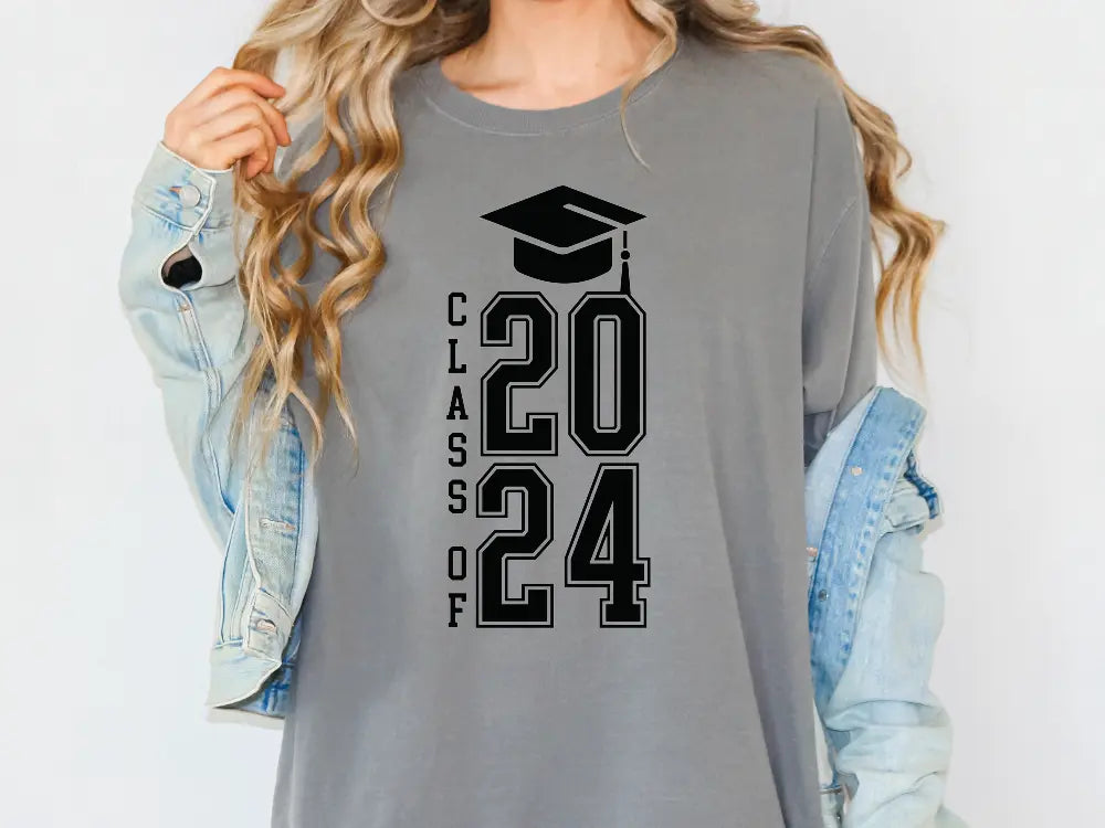 a woman wearing a gray shirt with a graduation cap on it