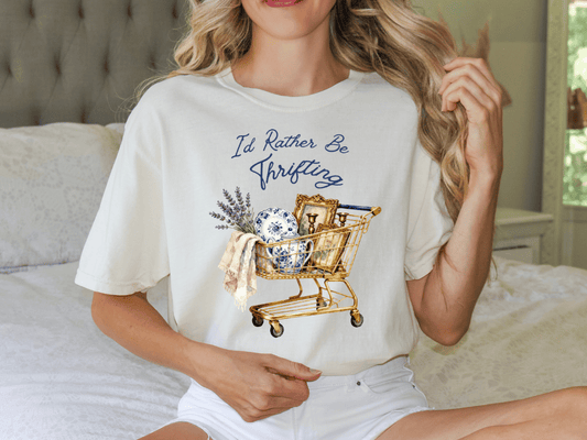 A woman wearing a white t-shirt with a graphic design of a shopping cart filled with various items, including a vase and a towel.