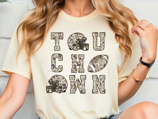 A person wearing a white t-shirt with the text "TOUCH DOWN" printed on it, along with various football-related graphics such as a helmet and a football.