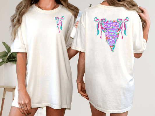 two women wearing white t-shirts with colorful designs on the back.