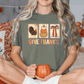 A woman sitting on a bed with a green t-shirt that says "Give Thanks" and holding a pumpkin-shaped mug.