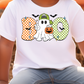 A white t-shirt with a graphic design featuring a ghost character and Halloween-themed elements, such as a pumpkin and bats.