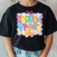 a young girl wearing a black t - shirt with a colorful design