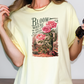 a woman wearing a t - shirt with a cactus and flowers on it