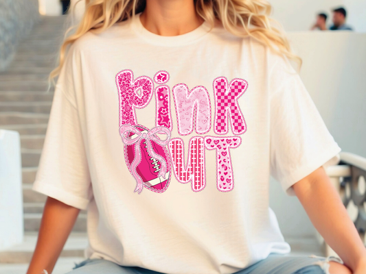 A person wearing a white t-shirt with the text "PINK OUT" printed on it.