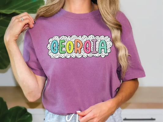 a woman wearing a purple shirt with the word georgia on it