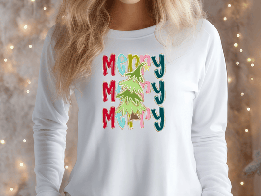 A woman wearing a white long-sleeved shirt with a colorful graphic design featuring the word "Merry" repeated in a festive pattern.