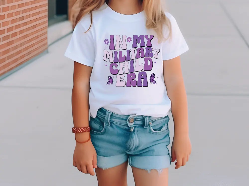 a little girl wearing a white shirt and blue shorts