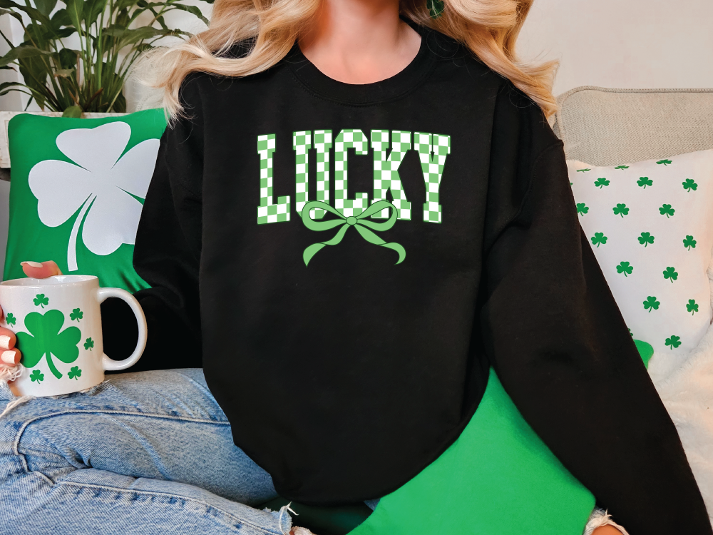 a woman sitting on a couch wearing a black lucky sweatshirt