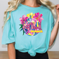 a woman with blonde hair wearing a turquoise shirt