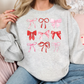 a woman sitting on a couch wearing a sweater with bows on it