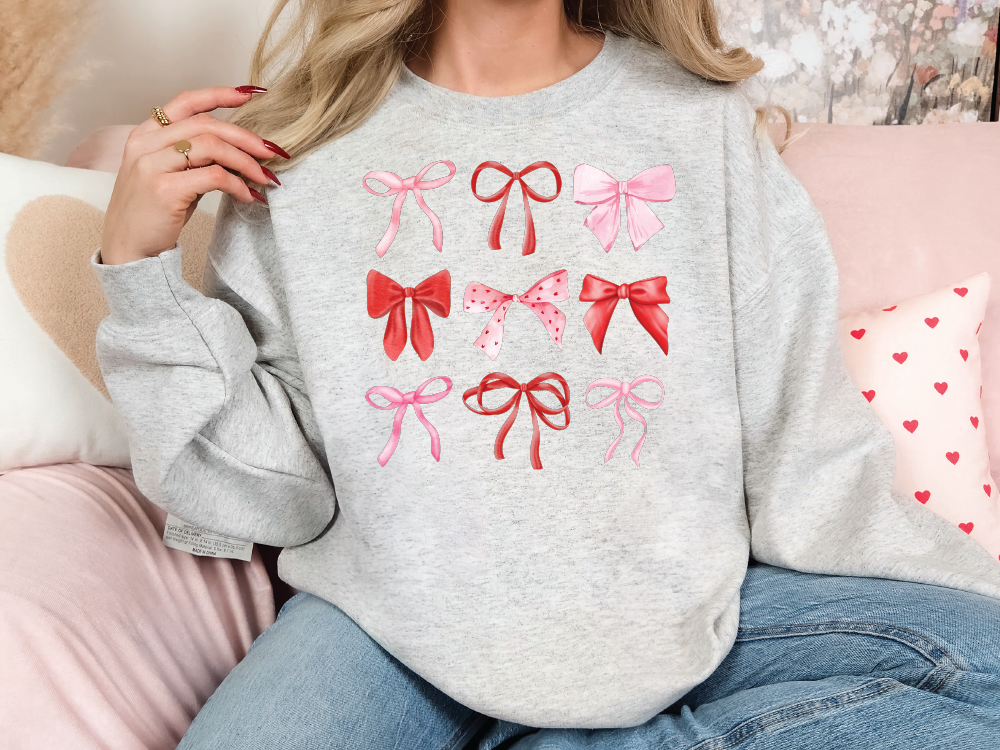 a woman sitting on a couch wearing a sweater with bows on it