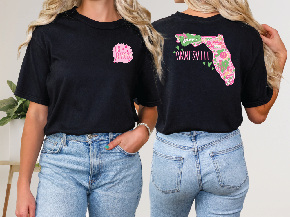 two women wearing black shirts with pink flowers on them