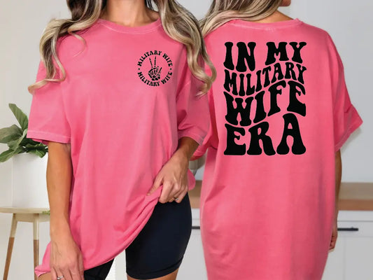 two women wearing pink shirts that say in my military wife era