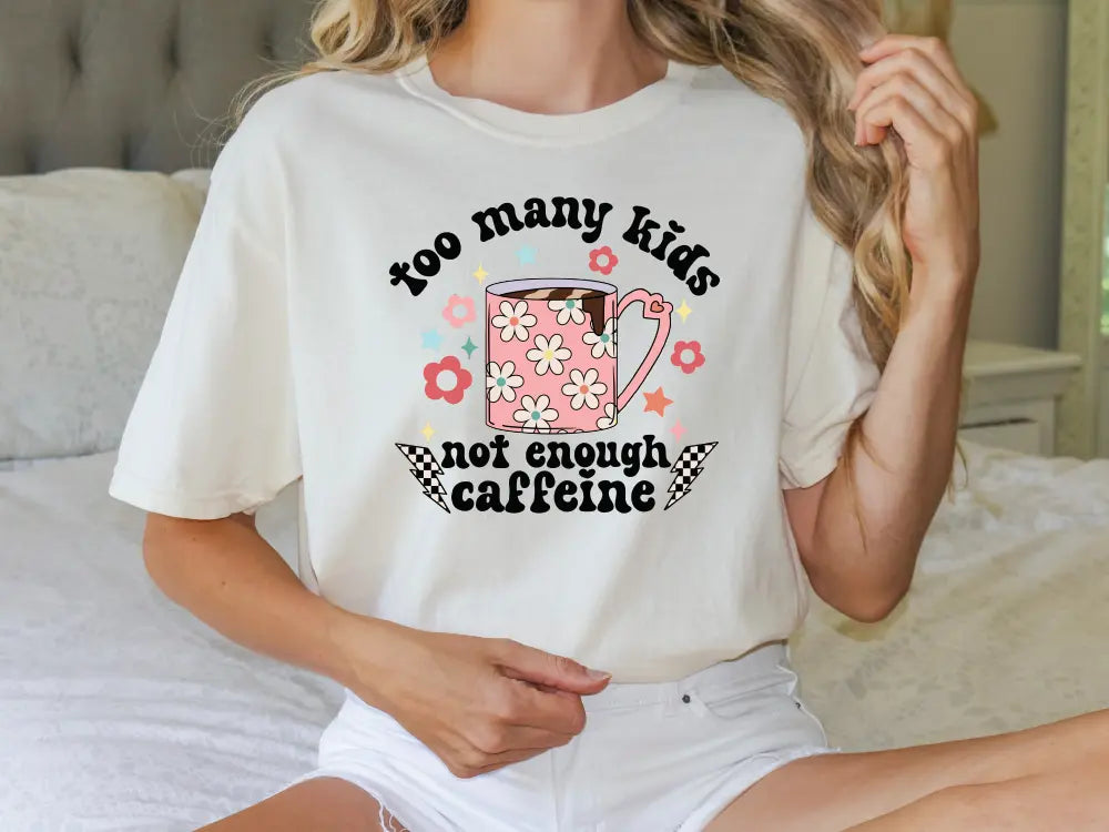 a woman wearing a t - shirt that says too many kids not enough caffe