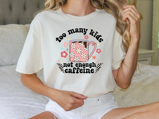 a woman wearing a t - shirt that says too many kids not enough caffe